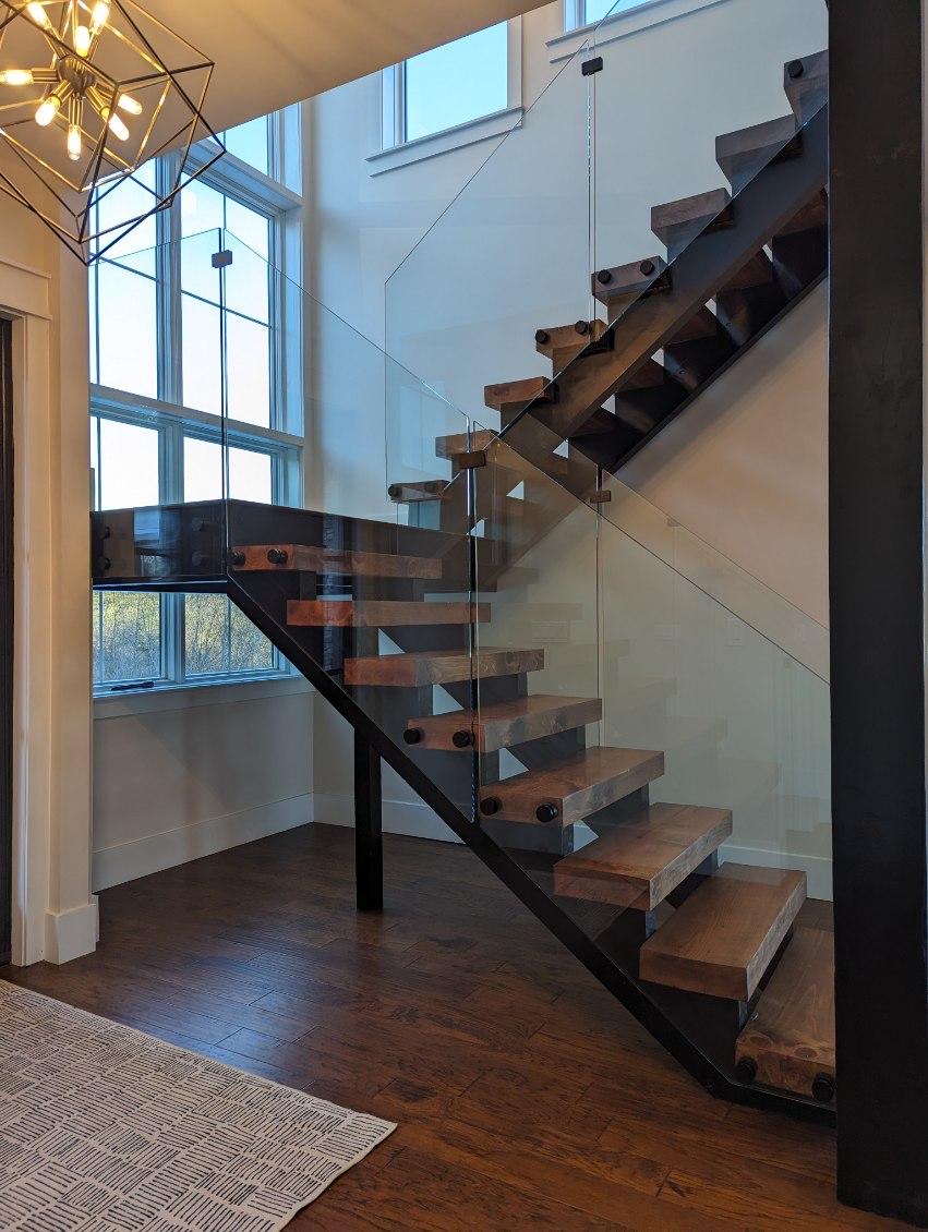 Interior stair with glass railing panels and wood treads.