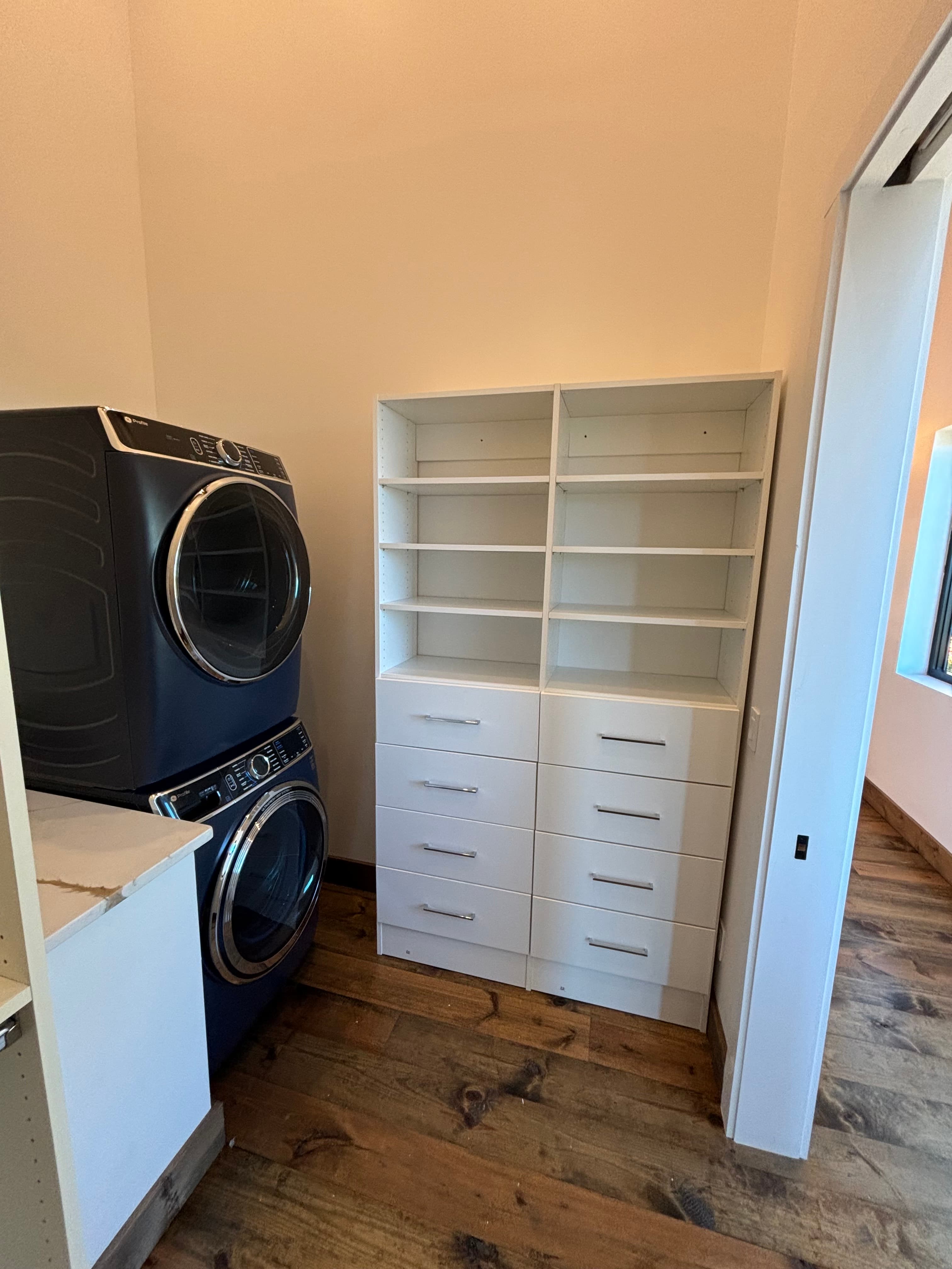 Installed closet organization system with shelving, drawers, and hanging storage.