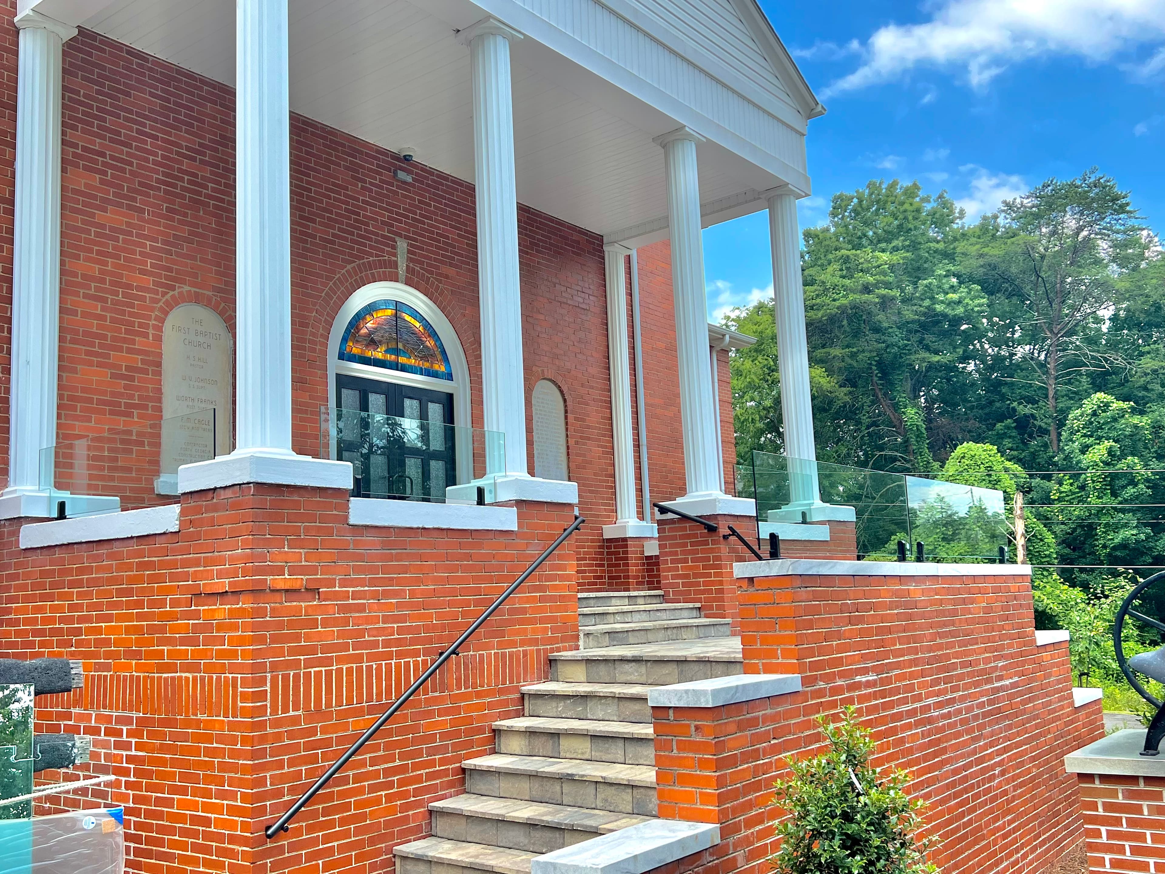Exterior glass railing on a deck or balcony overlooking a mountain view.