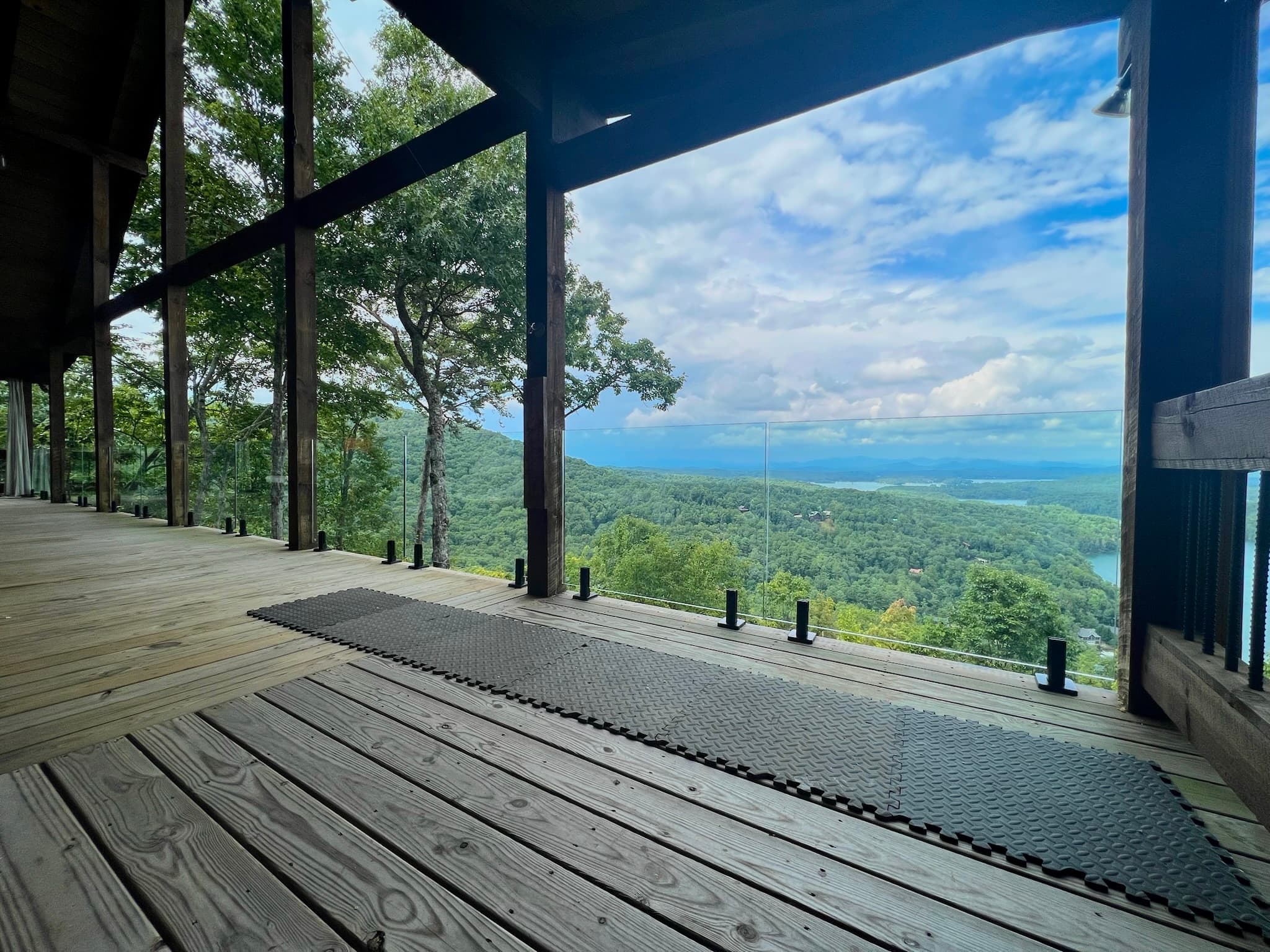 Exterior glass railing on a deck or balcony with mountain views.