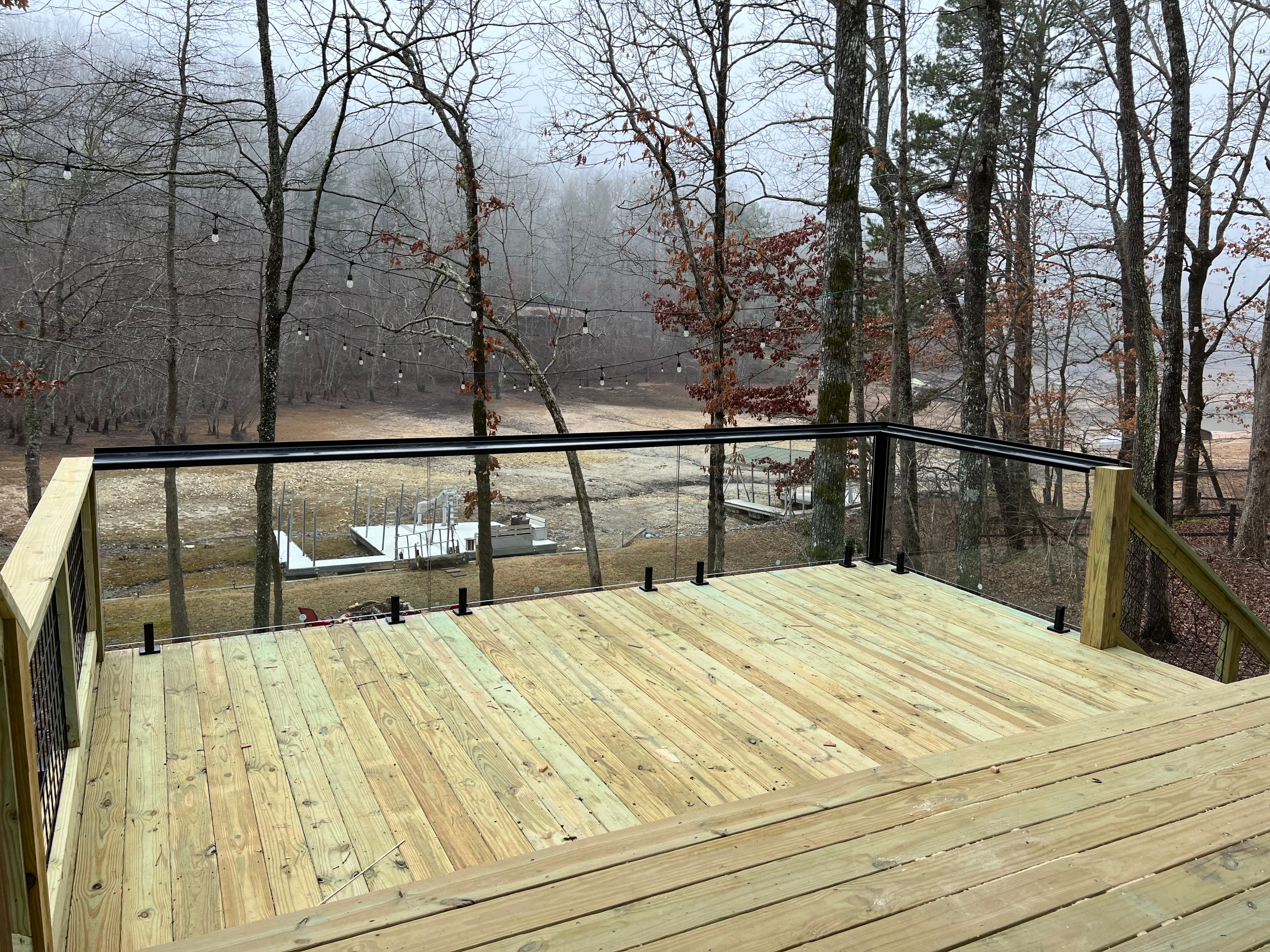 Exterior glass railing installation on a deck with post and panel layout.