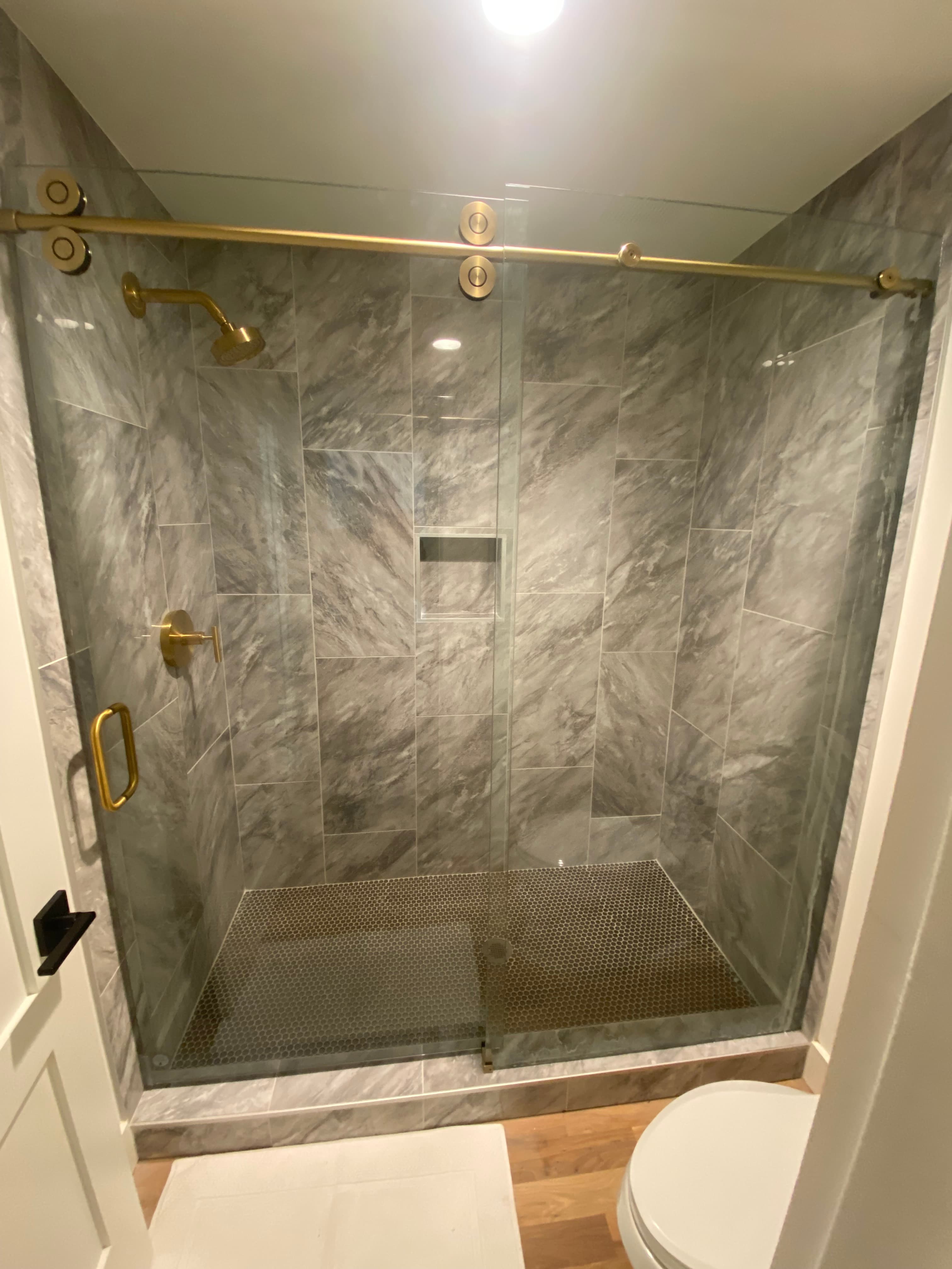 Frameless shower door hardware and hinge detail.