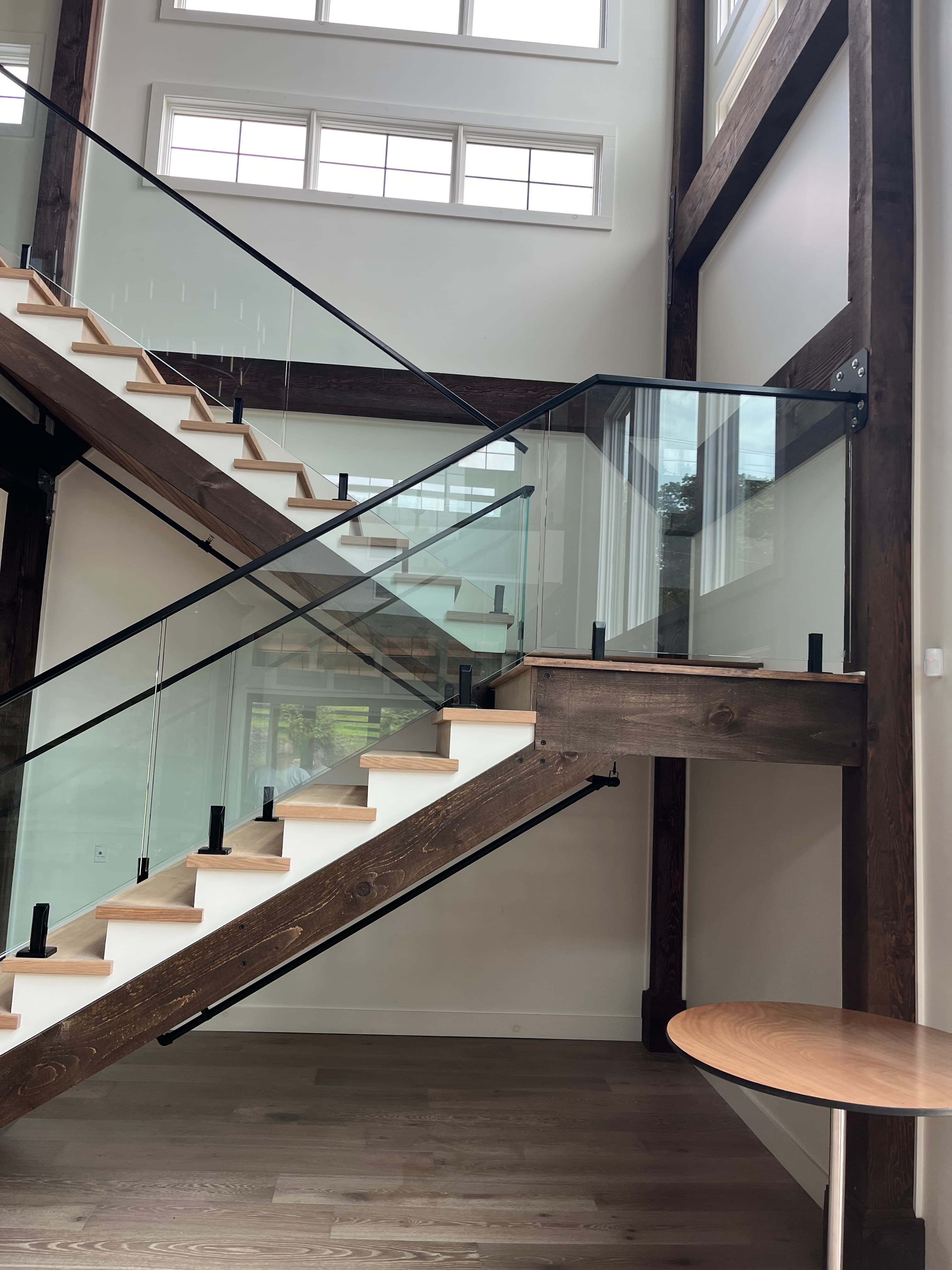 Interior stair with glass railing—clear guards and wood treads.