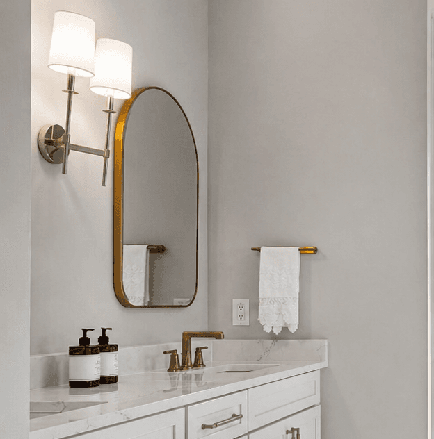 Custom bathroom mirror with vanity lighting in a residential bath.