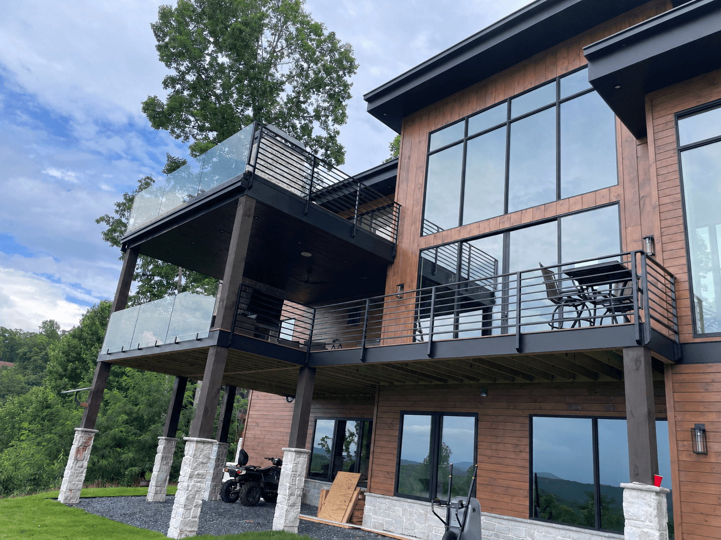 Exterior glass railing on a deck or balcony with mountain views.