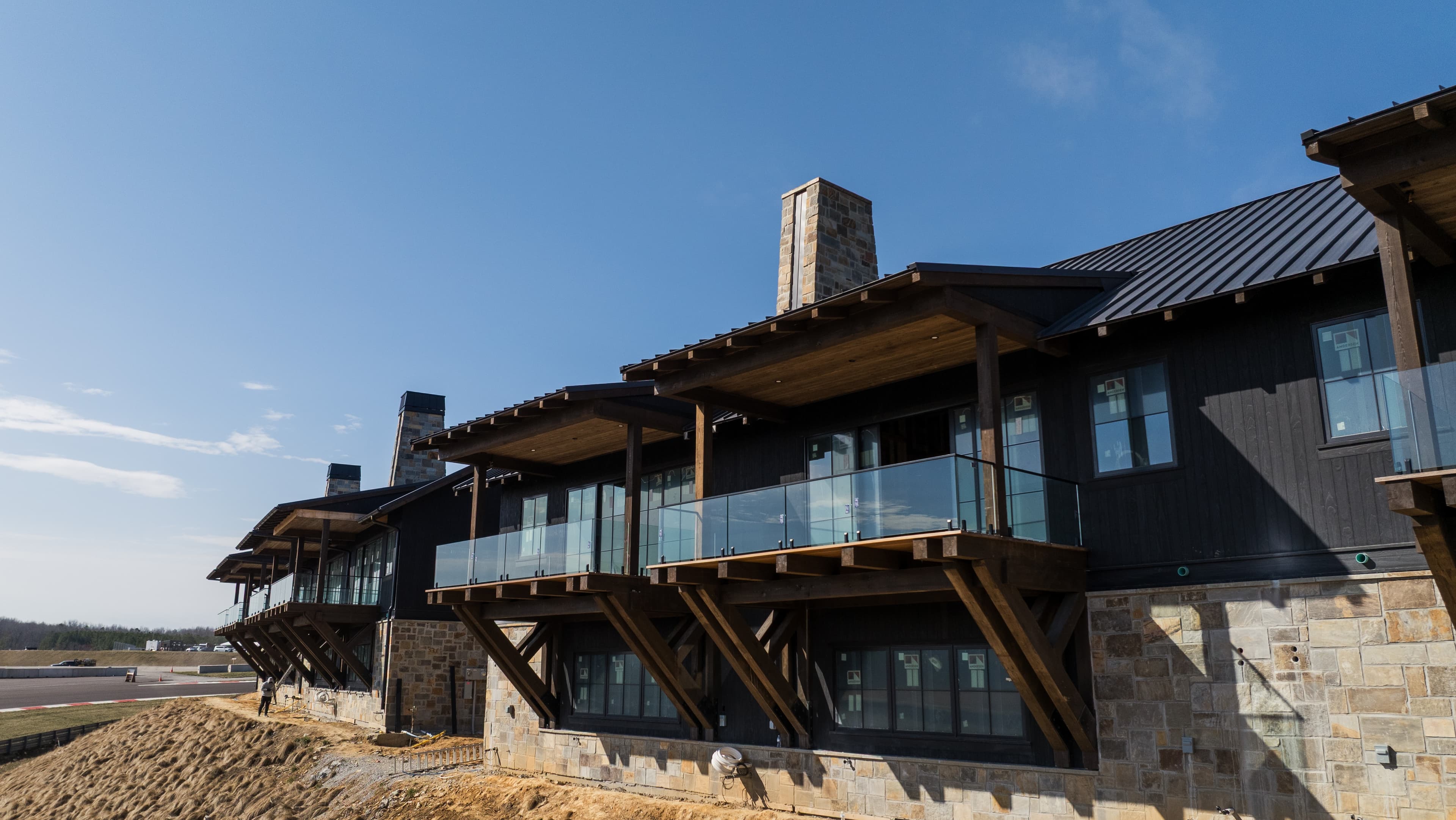 Exterior glass railing system with clear panels and metal posts on a residential deck.