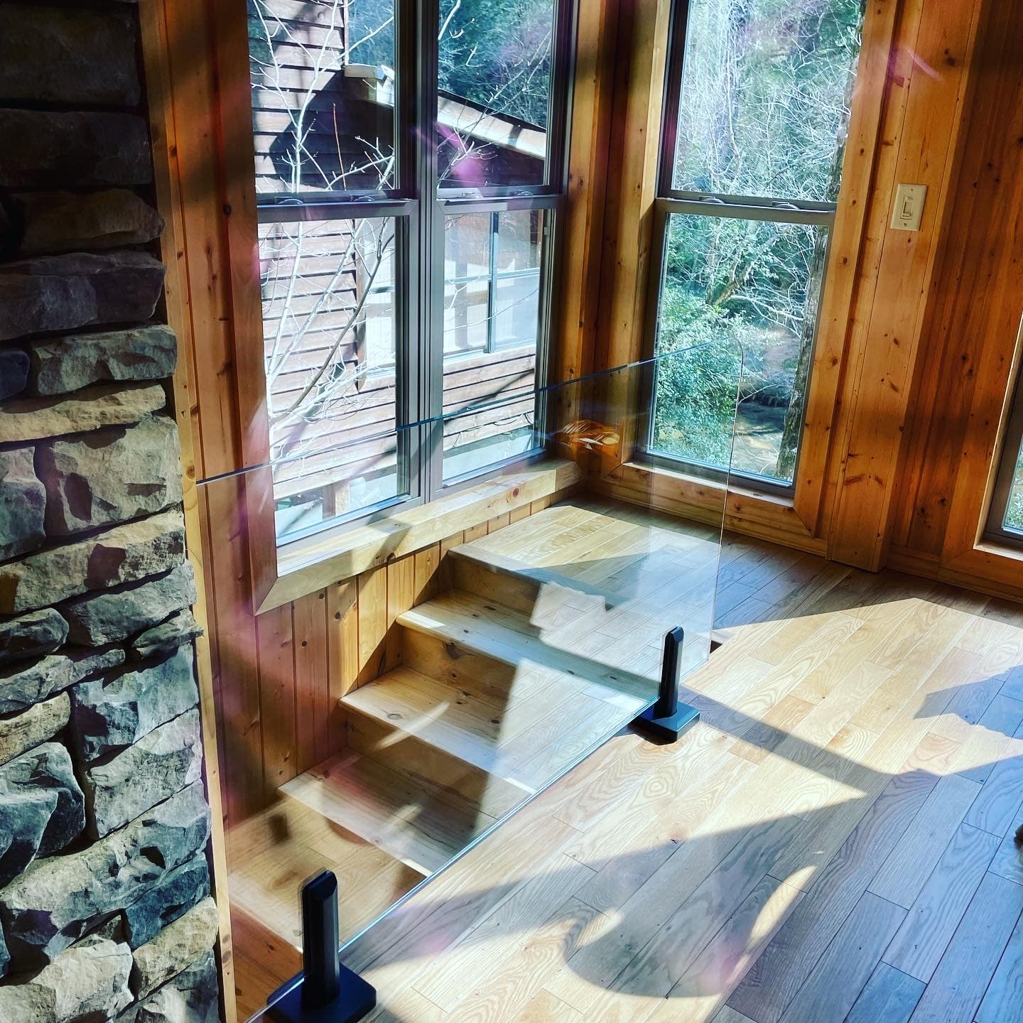 Interior glass railing on a residential stair and landing.