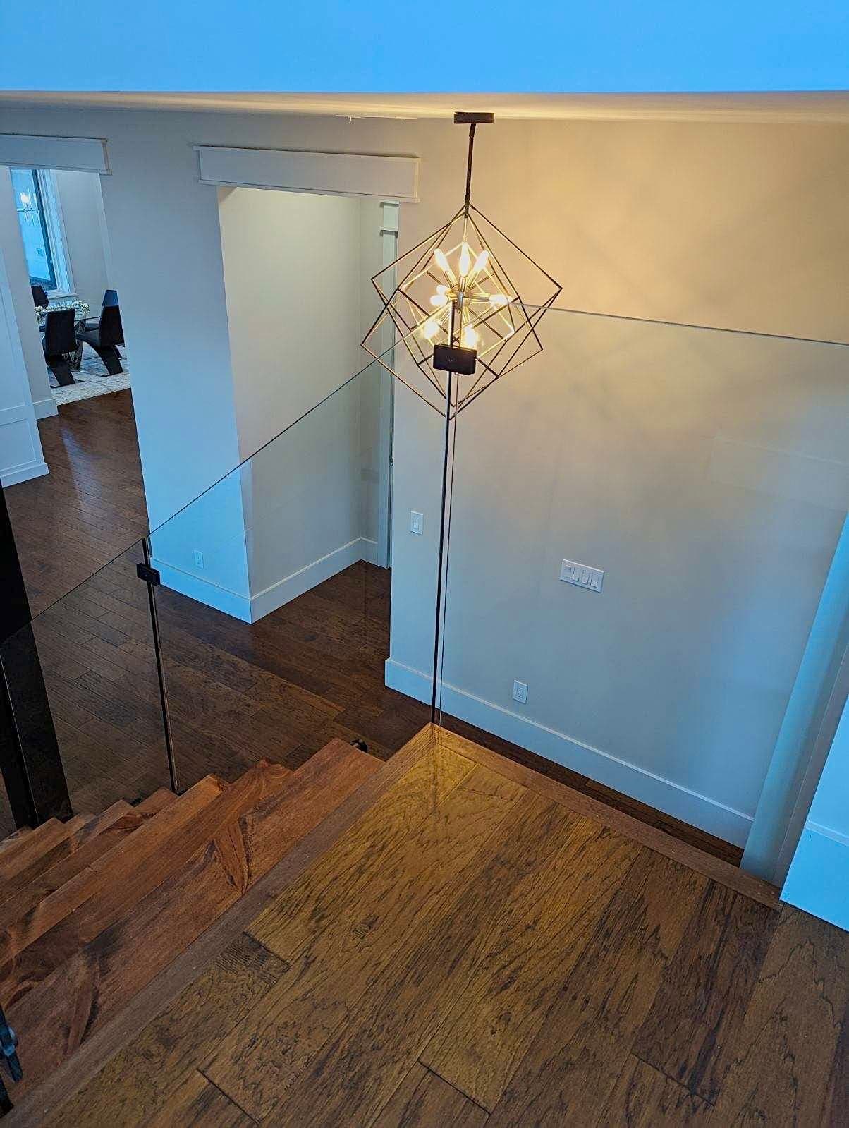Interior glass railing on a residential stair and landing.