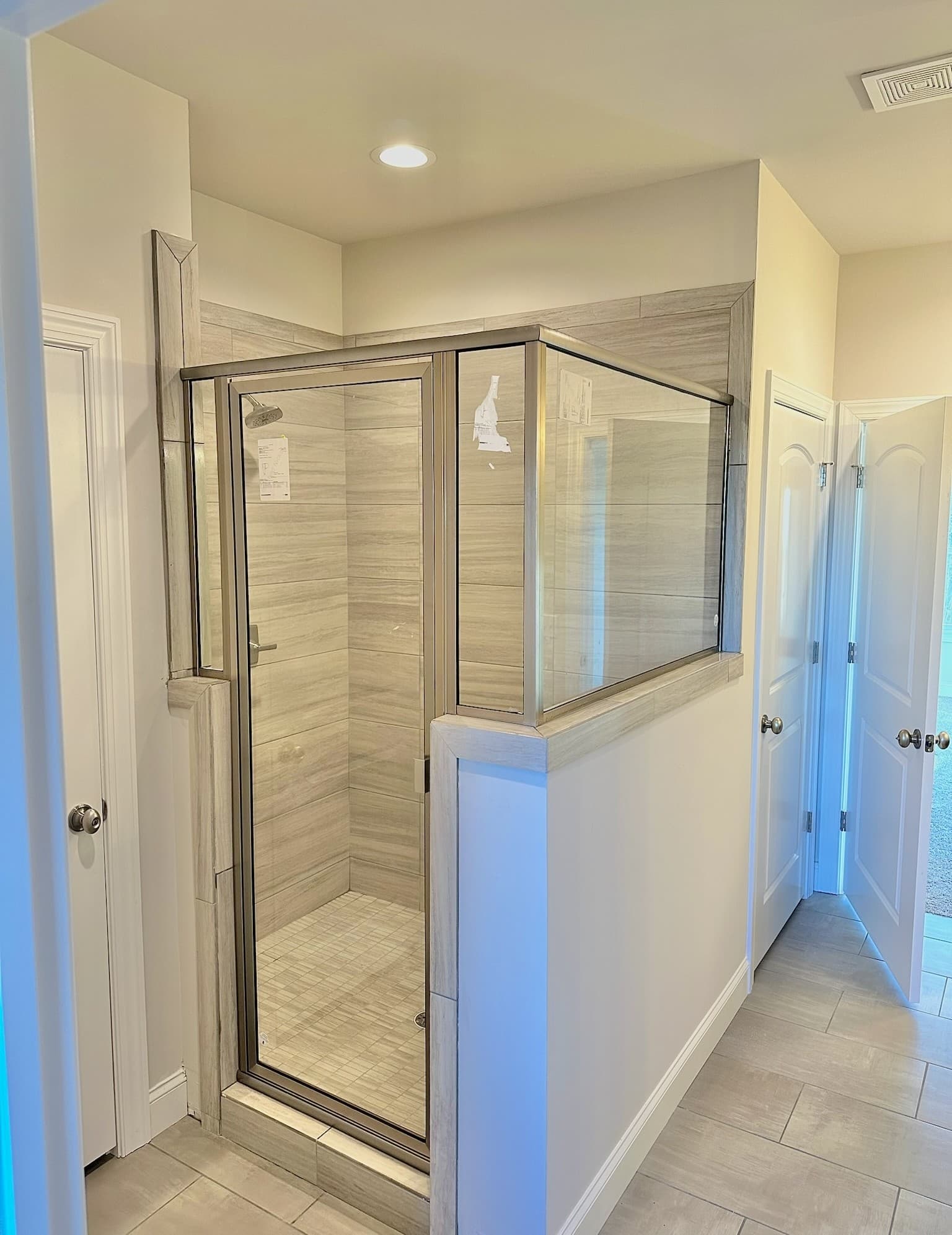 Shower glass and metal hardware—door pulls, hinges, and bath fixture finishes for coordination context.