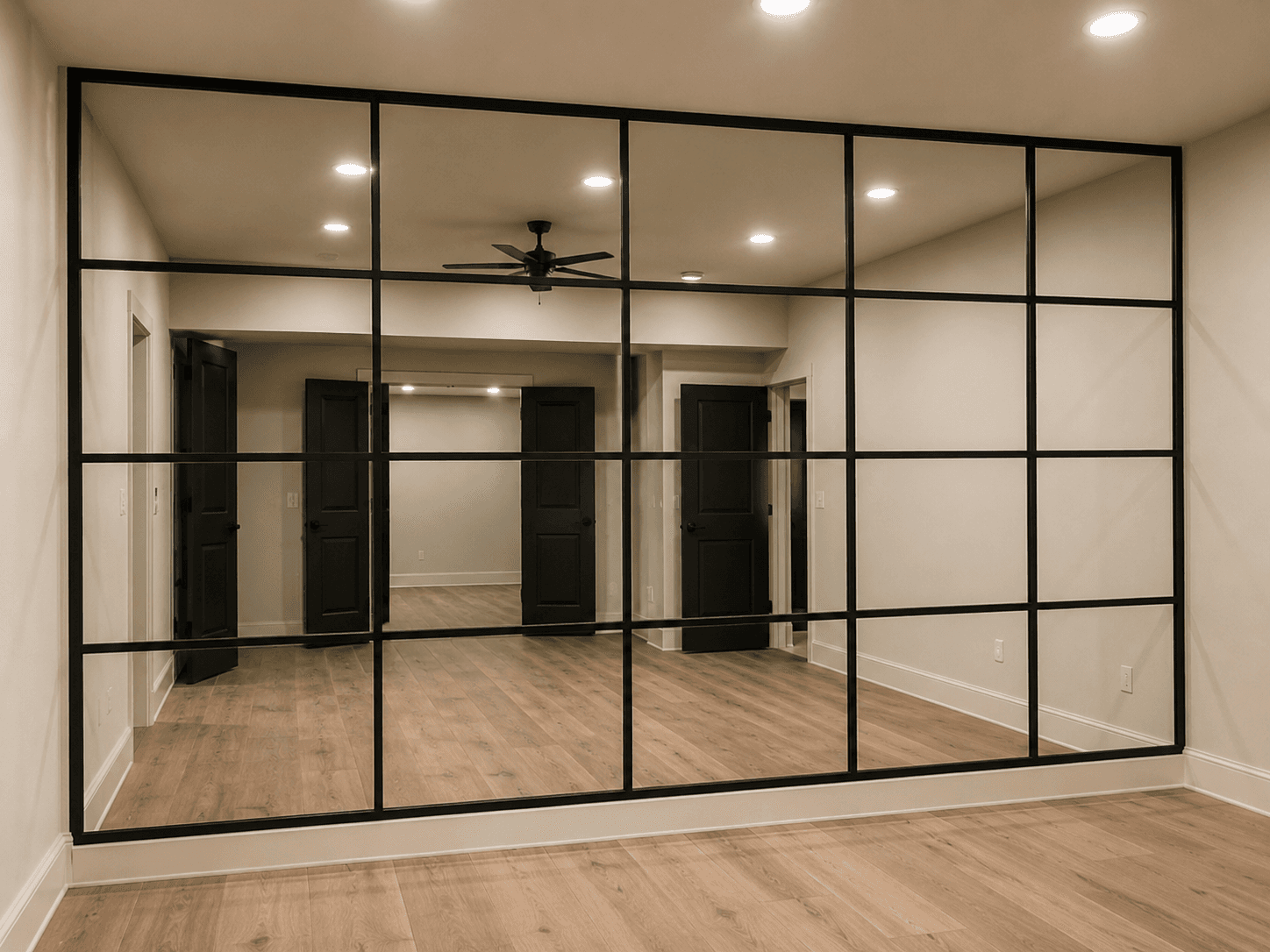 Large wall mirror installation in a home gym or studio space.