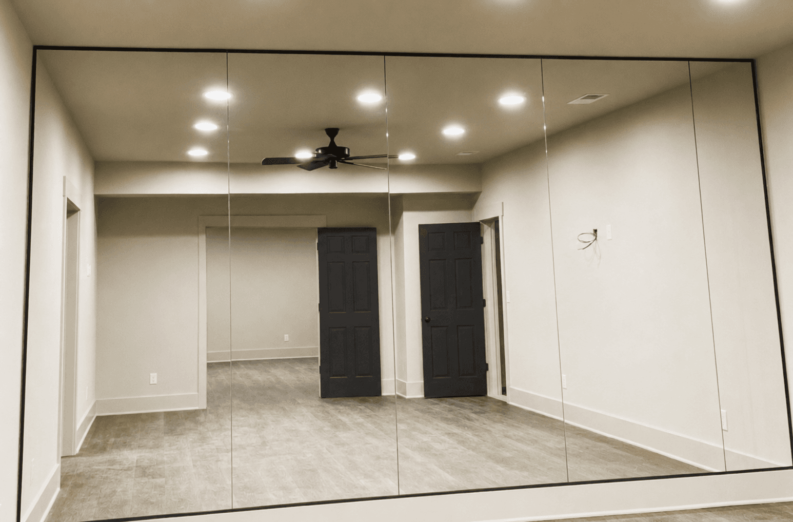 Wall mirror measurement and installation in a gym or studio space.